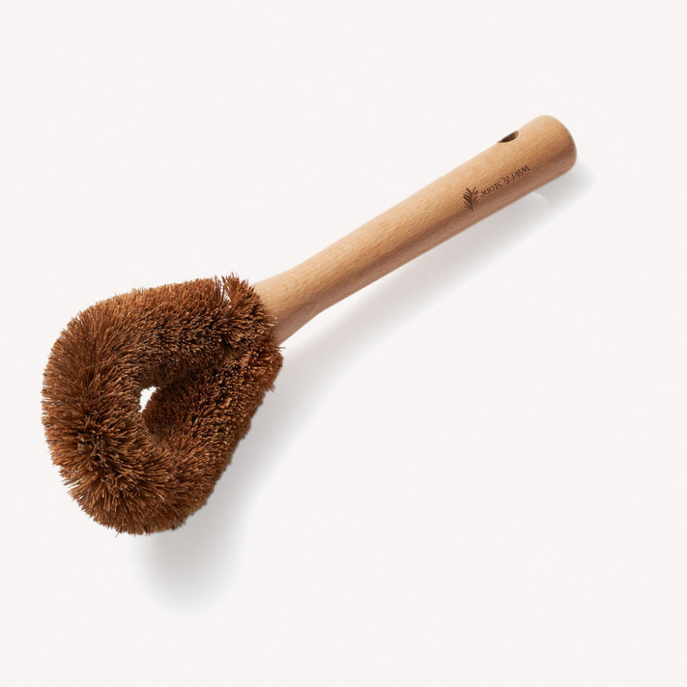Wooden dish brush with brown bristle head on a white background