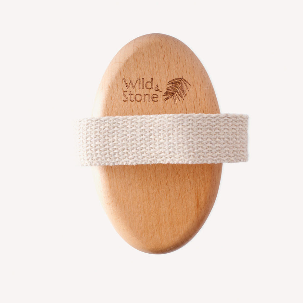 Wooden brush with a white handle band on a white background, branded 'Wild & Stone'.