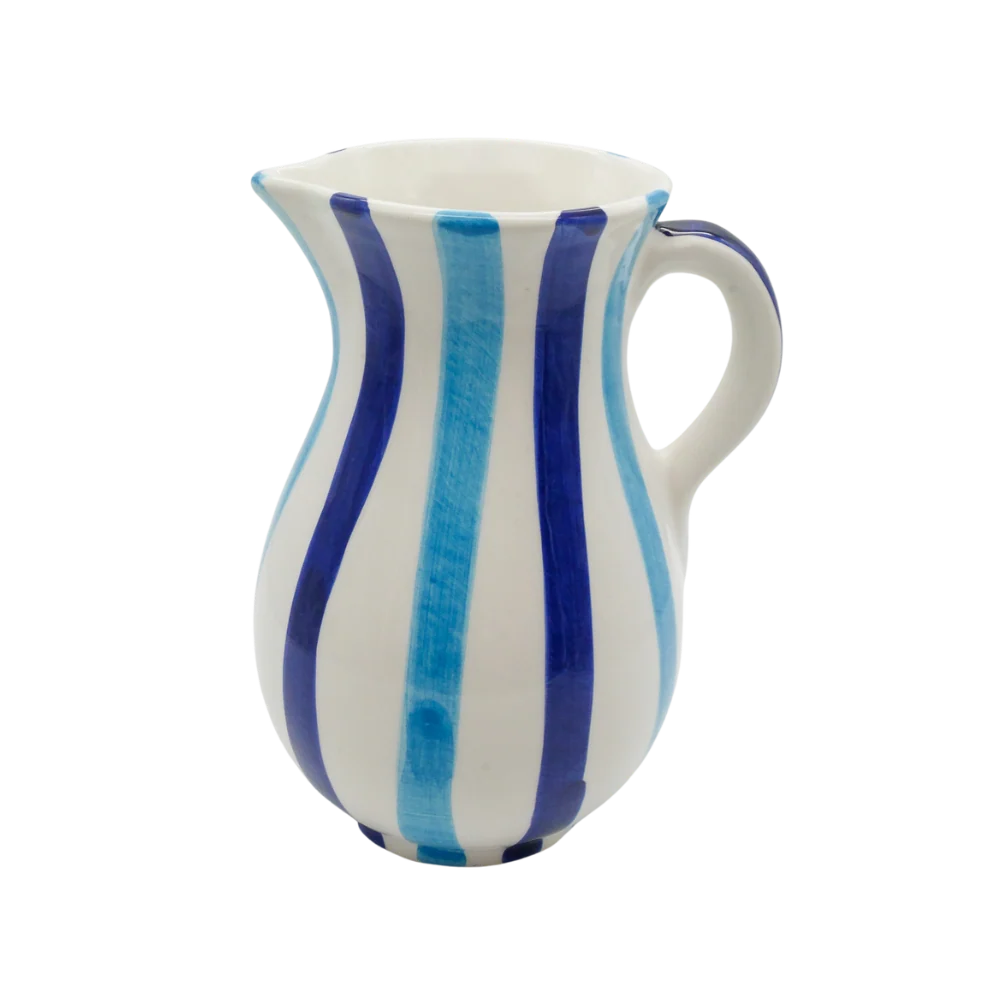 A white ceramic pitcher with vertical hand-painted stripes in shades of blue, including navy and light blue, shown on a plain white background.