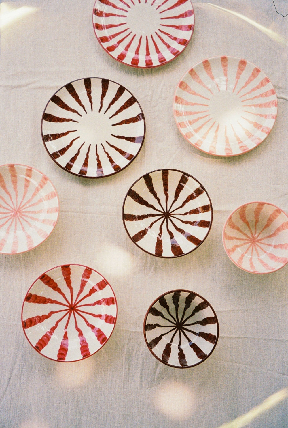 Overhead view of pink striped ceramic bowls and matching plates