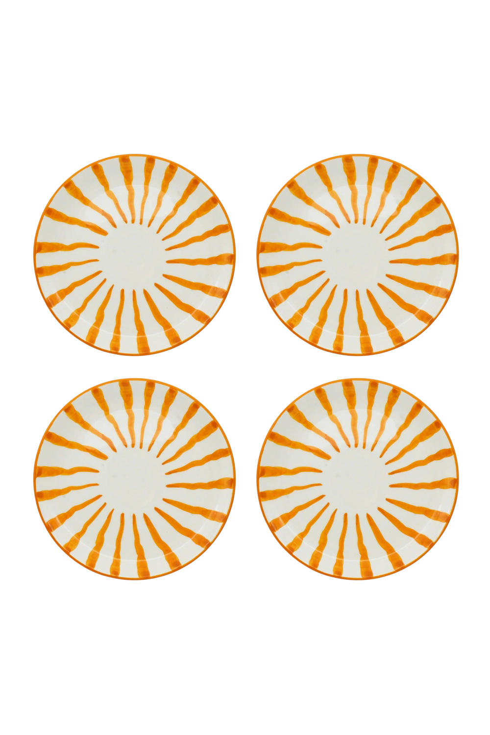 Four round white plates arranged in a 2x2 grid, each decorated with a radial orange sunburst pattern and a solid orange rim.