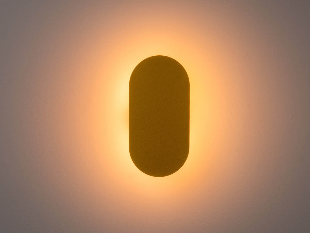Yellow mini diffuser wall light switched on with soft ambient glow