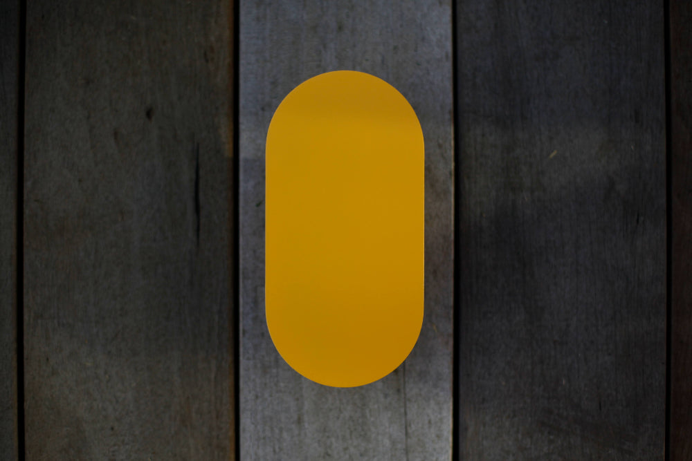 Yellow wall light styled on an outdoor patio wall